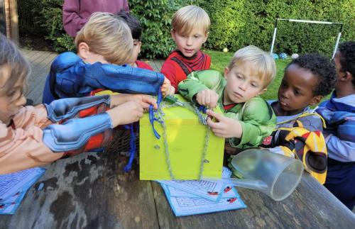 Superhelden proberen de slotenkoffer te openen tijdens het Babar-superheldenfeestje