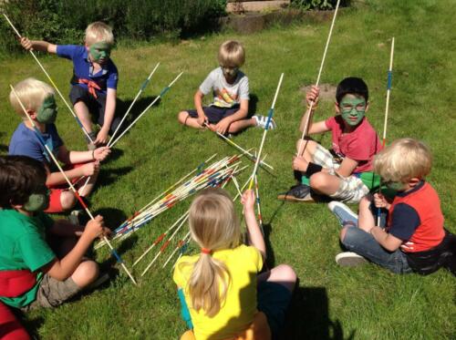 Kinderen spelen met reuze mikadostokken