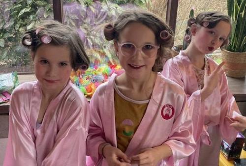 Twee meisjes in roze badjassen genieten van de sjieke madammenkoffer van Babar