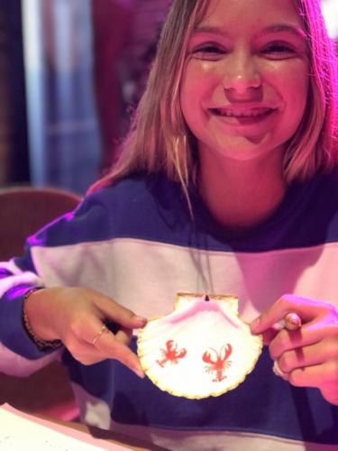 vrouw toont trots haar versierde schelp