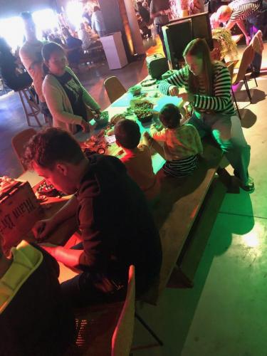 Tafel vol blije kinderen die schelpen versieren
